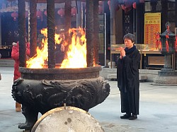 Mujer rezando en Shánghai - China